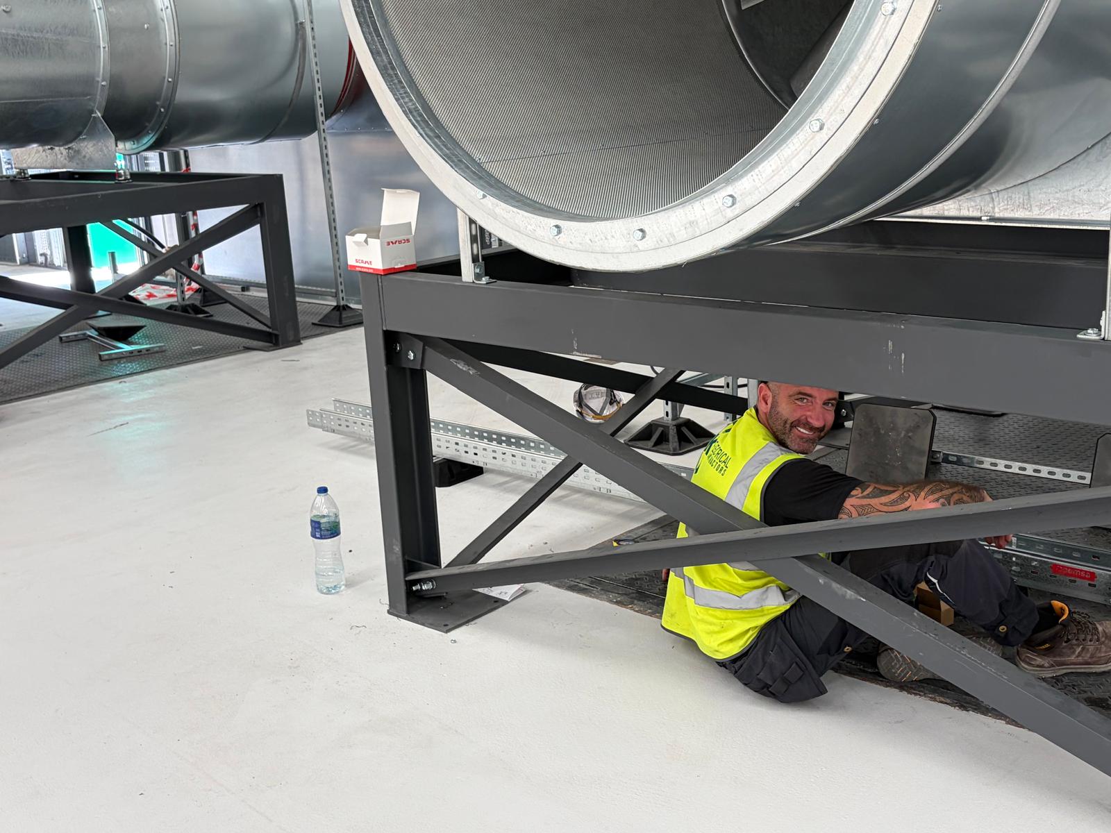 CK operative installing containment beneath ventilation plant